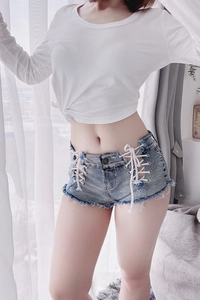 Dettaglio di pantaloncini di jeans a vita alta con lacci laterali e orlo a vivo