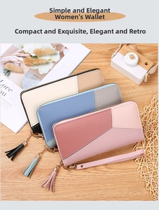Detail view of stylish tri-color long wallets with tassels and wrist straps on a wood desk