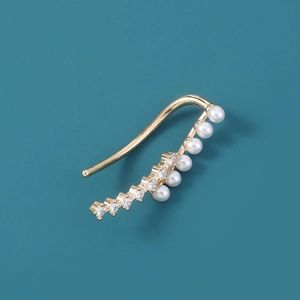 Detail of gold star ear cuff with embedded pearls and diamonds on blue background