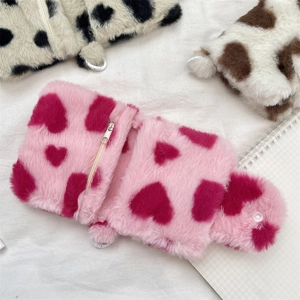 Close-up of a pink plush coin storage pouch featuring dark pink heart patterns and zipper detail