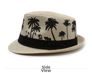 Detail view of woven straw fedora hat featuring black palm tree and bird print patterns