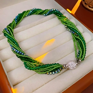 Gros plan d'un bracelet multi-rangs en perles vertes avec un fermoir en cristal brillant