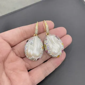 Baroque pearl earrings with gold hooks and colorful handset Czech crystals on gray background