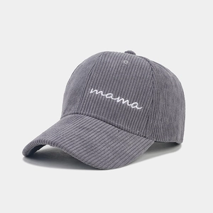 Close-up of grey corduroy baseball cap with white mama embroidery and ribbed texture