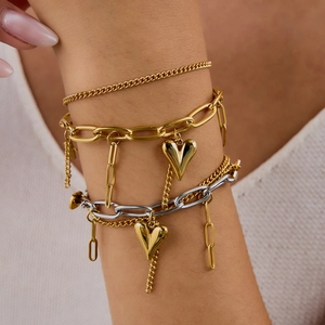 Close-up of layered stainless steel heart bracelets with gold and silver chain details