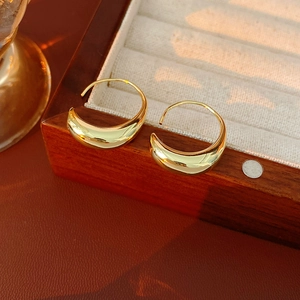 Macro shot of 14k gold plated oval hoop earrings with a polished metallic finish