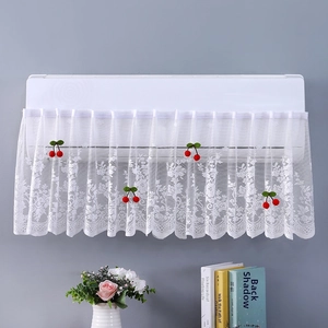Close-up of lace air conditioner cover with floral embroidery and cherry charms