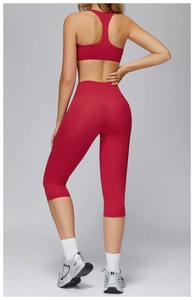 Rear view of red racerback sports bra and high-waisted capri yoga pants set on a model
