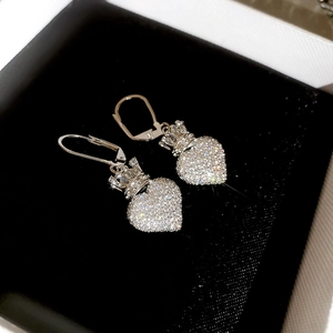 Close-up of crown heart earrings with clear zircon pavé in a black velvet jewelry box
