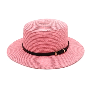 Detail of pink straw boater hat with a black leather band and gold buckle accent