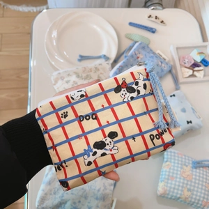 Detail shot of mini cotton pouch with cartoon dog print and blue woven rope zipper pull