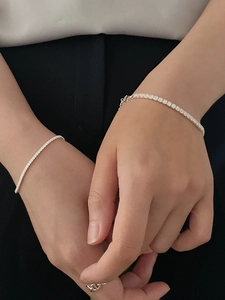 Close-up of stacked sterling silver tennis bracelets with cubic zirconia on a wrist