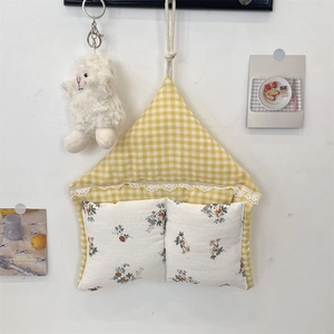 Détail du sac de rangement mural en forme de maison avec tissu à carreaux et dentelle