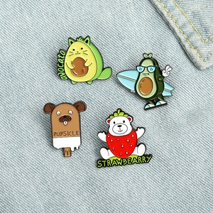 Set de pines de esmalte con aguacates de dibujos animados y oso fresa sobre tela vaquera