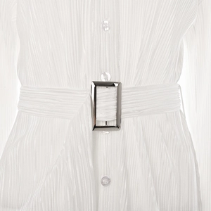 Detailed macro view of white pleated waistline with silver buckle and matching belt
