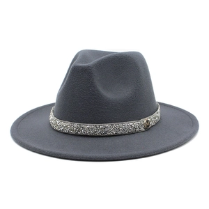 Close-up of a grey wool fedora hat featuring a sparkling rhinestone band and silver M badge