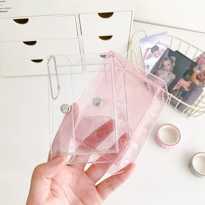 Detail of transparent pink glitter PVC card holders with metal bead chains and snap buttons