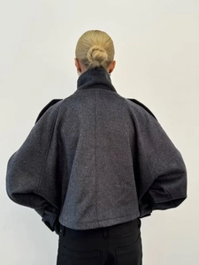 Rear view of a dark grey loose-fitting woolen coat with drop shoulders and cocoon silhouette
