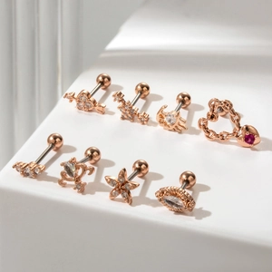 Detail view of 8 rose gold cartilage earrings with heart and star crystal accents