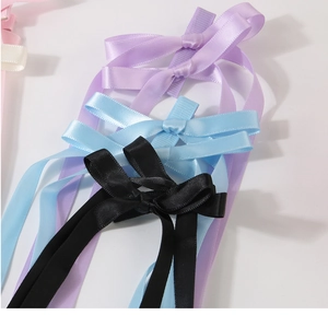 Close-up of colorful satin bow hair clips with long streamers in multiple pastel colors