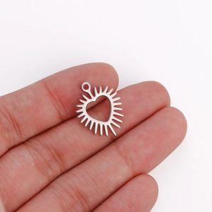 Macro detail of silver heart pendant with sunburst rays for DIY jewelry making