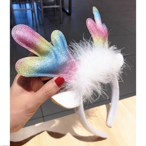 Detailed view of rainbow sequined reindeer antlers headband with white feathers