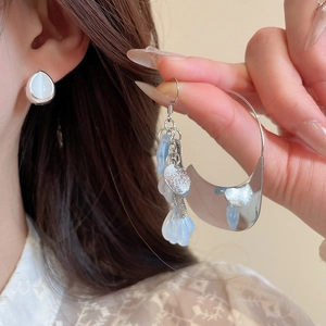 Detailed macro view of acrylic petal tassel earrings with white opal studs and silver accents