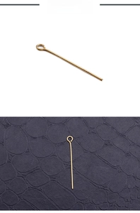 Close-up of golden stainless steel eye pins for DIY earring making on textured leather