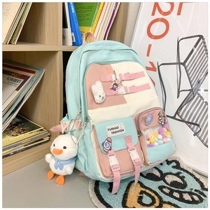 Detail of school backpack featuring aesthetic color blocks and cute hanging plush toys