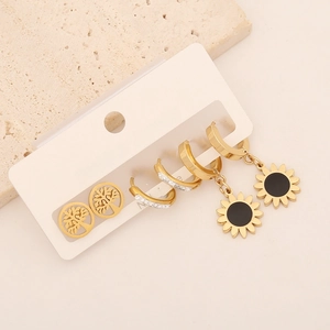 Detailed view of 3-pair gold earring set featuring sunflower pendants and zircon studs