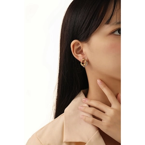Minimalist irregular geometric two-tone lava texture stud earrings shown on a model