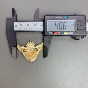 Detailed measurement of gold winged heart ring showing 40.6mm width with a digital caliper