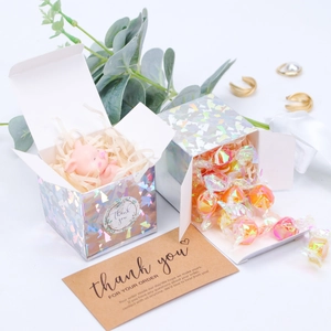 Holographic silver gift box detail with thank you sticker and kraft paper card