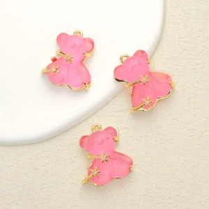 Close-up of three pink resin bear charms with gold edges and sparkling zircon inlay