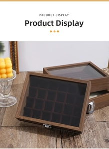Macro shot of walnut wood jewelry box featuring clear glass lid and multi-slot ring display
