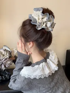 Detail of checkered hair scrunchie with white lace trim on high ponytail