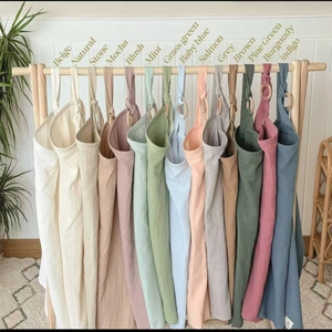Close-up of dual-layer cotton nursing covers in assorted Morandi colors with wooden ring detail