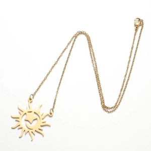 Detail of a golden sun pendant necklace with hollow carving on a thin link chain
