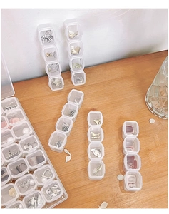 Macro detail of transparent acrylic jewelry organizer box on wooden background