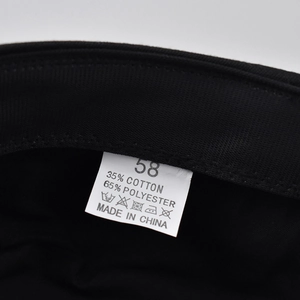 Close-up of the care label inside the black beret showing 35% cotton and size 58