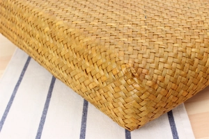 Close-up macro detail showing natural hand-woven straw bag texture and craftsmanship