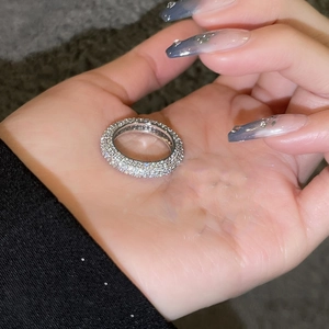 Detail of silver-plated wide band ring featuring rows of pave-set micro zircons