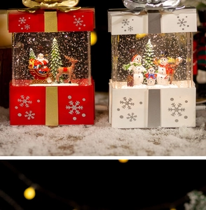 Close-up of Santa and Snowman crystal ball gift boxes with warm LED glowing lights