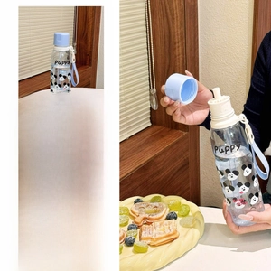 Detail of blue cartoon plastic water bottle with Puppy print and convenient hand strap