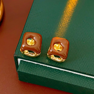 Close-up of French vintage square earrings with brown enamel on a green jewelry box