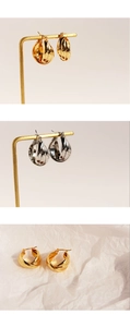 Detail showing gold and silver multi-layer twisted hoop earrings on display stands