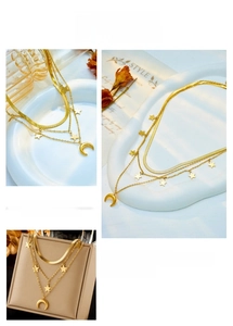 Detailed close-up of triple-layered gold star and moon necklace on a display stand