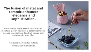 Detail of pink ceramic handle fruit forks in a textured storage jar with golden finish