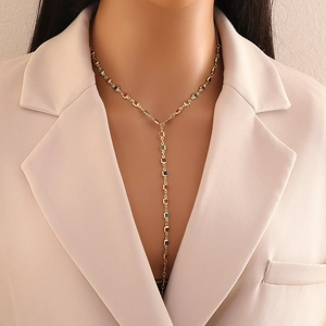 Elegant gold Y-shaped necklace with colorful square beads worn by a model in close-up view