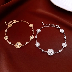 Close-up of 18K gold plated adjustable bracelets with starburst charms on silk fabric